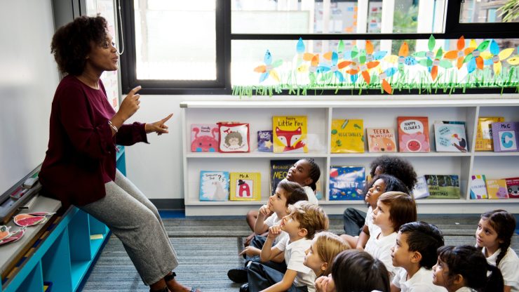 A teacher engages a captivated group of children, fostering a supportive and encouraging learning environment.