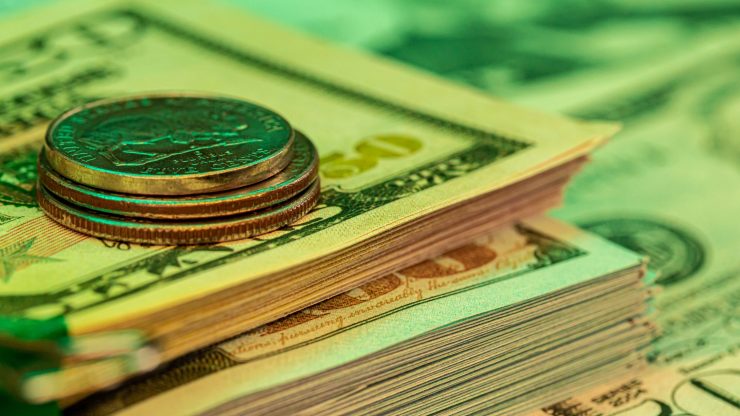 A focused arrangement of coins atop neatly stacked bills conveys financial stability and assurance.