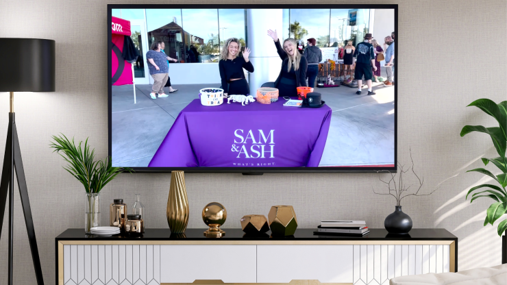 Two welcoming advocates engage with the community, promoting support and awareness in a vibrant setting.