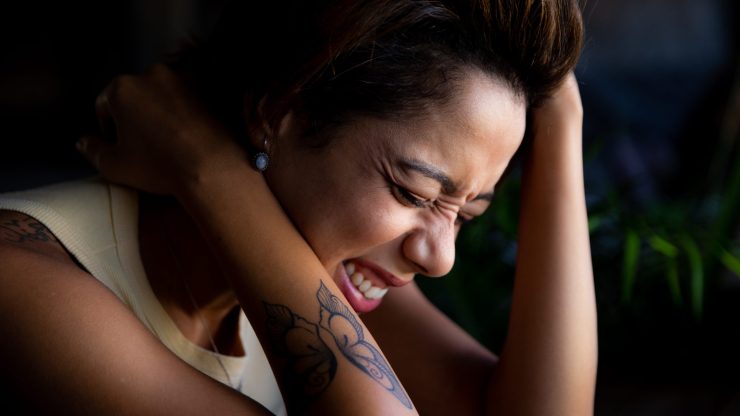 A woman expresses deep emotion, conveying strength and resilience in a supportive environment.