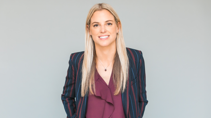 Confident professional exuding warmth and advocacy, set against a neutral background.