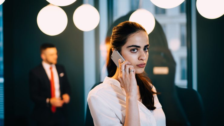 A confident professional engages in a serious phone conversation, showcasing dedication and support.