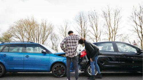 two people looking at their car accident