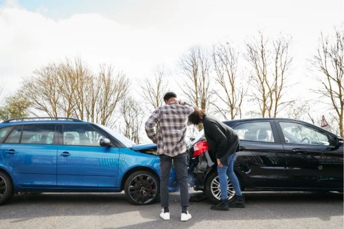 two people looking at their car accident