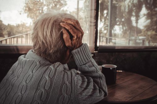 elderly person looking out the window