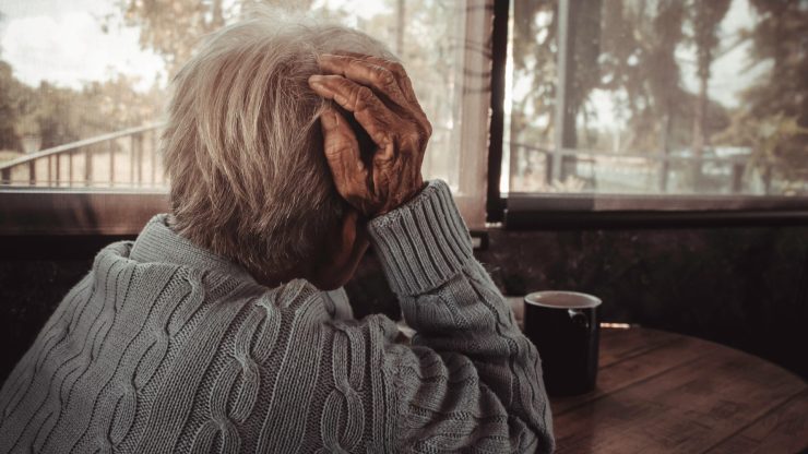 elderly person looking out the window