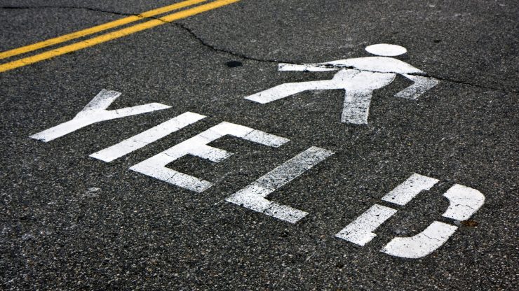 yield ot pedestrians painted on street