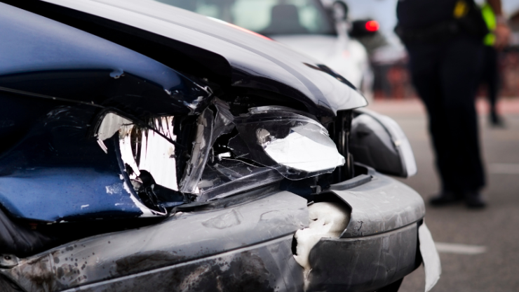 A damaged vehicle at an accident scene, with police assessing the situation, conveys urgency and care.