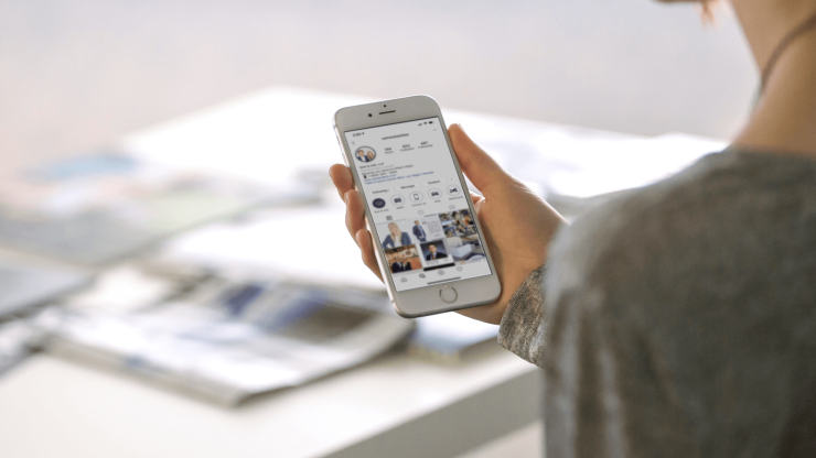 A person engages with a smartphone, conveying accessibility and modern advocacy in a professional setting.