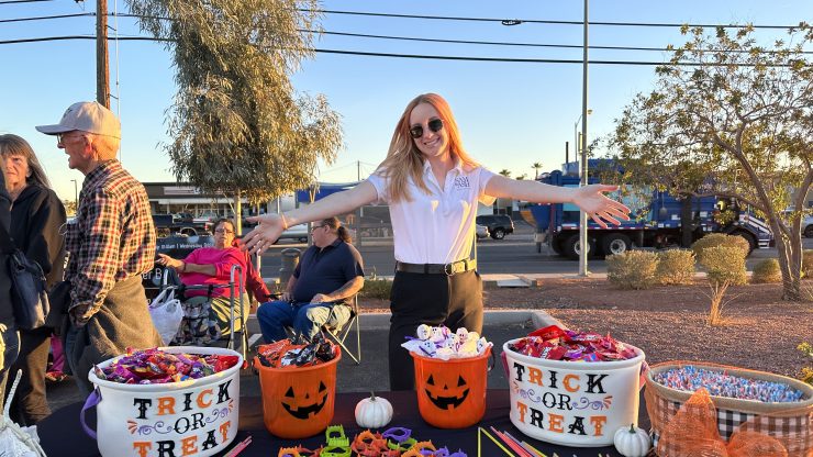 A welcoming atmosphere with a friendly advocate engaging families at a festive community event.
