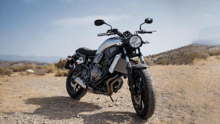 A motorcycle stands confidently in a rugged landscape, symbolizing freedom and adventure.