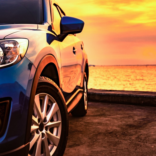 A sleek vehicle against a vibrant sunset, symbolizing resilience and hope in challenging times.