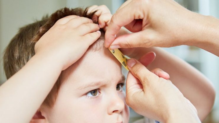 A concerned adult gently tends to a child's injury, reflecting care and compassion in a supportive environment.