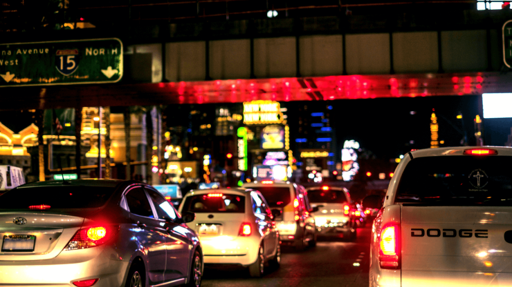 A bustling nighttime scene, showcasing traffic under vibrant city lights, evokes urgency and care.