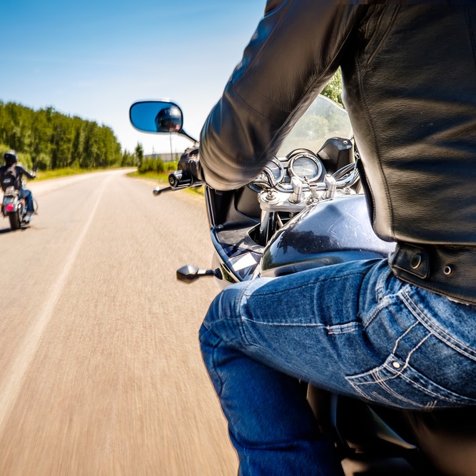 Riding confidently on an open road, showcasing freedom and camaraderie among motorcyclists.