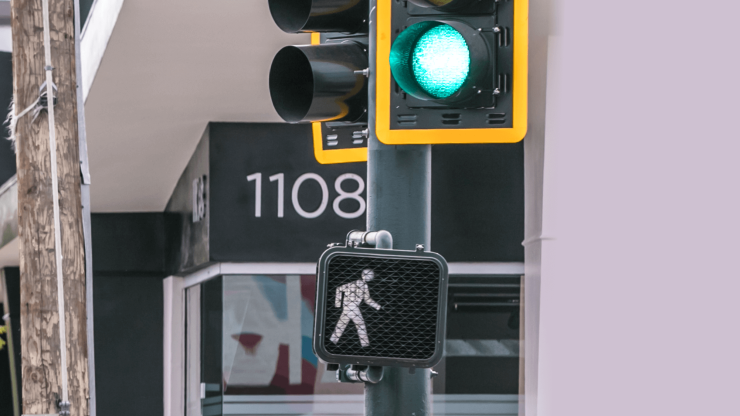 A green pedestrian signal indicates safety and readiness to cross, symbolizing care and advocacy.