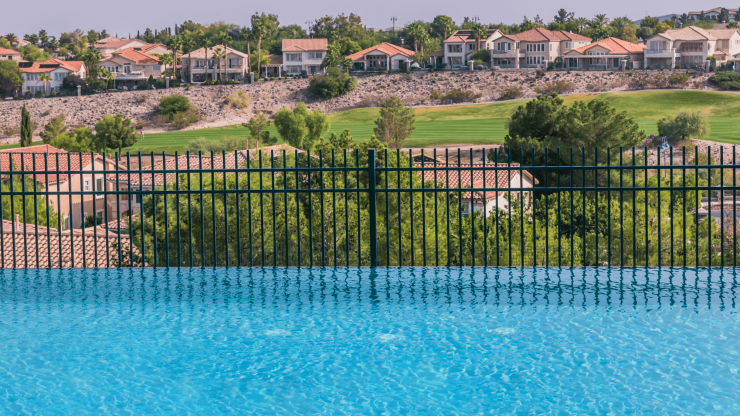 A serene pool reflects a tranquil landscape, suggesting safety and comfort in a vibrant community.