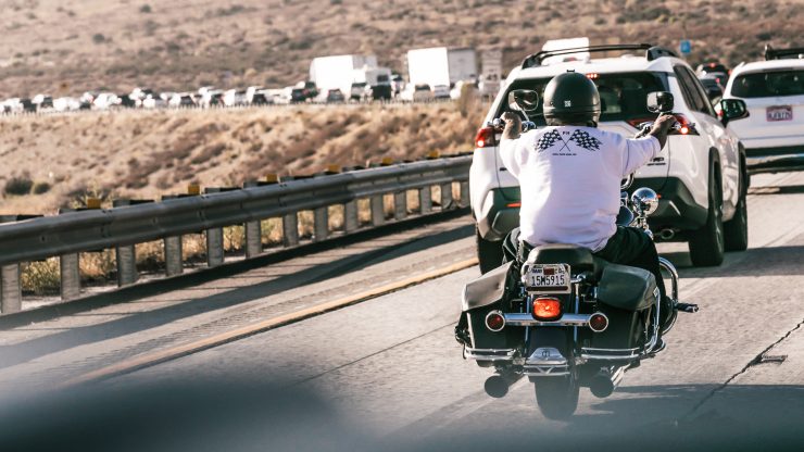 A motorcyclist navigates traffic, embodying resilience and determination in a challenging environment.