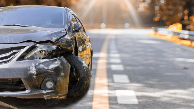 A damaged vehicle on a quiet road, evoking a sense of urgency and the need for legal support.