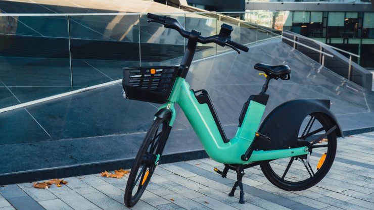 A vibrant bike stands in a modern urban setting, symbolizing mobility and community engagement.