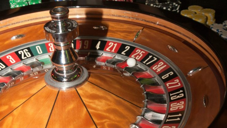 A dynamic casino scene captures focused players engaged in a game of roulette, highlighting strategy and chance.