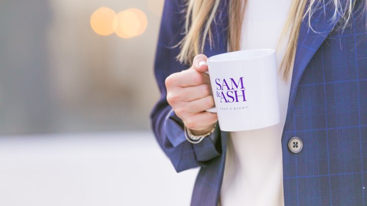 A confident professional holds a branded mug, embodying care and advocacy in a welcoming environment.