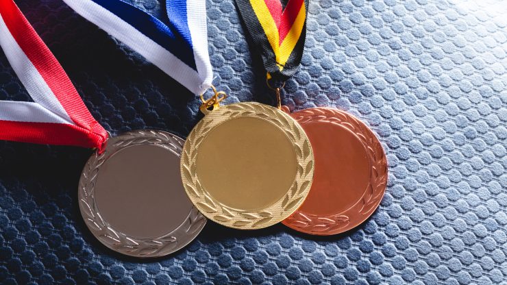 Medals in gold, silver, and bronze symbolize achievement and resilience, reflecting dedication and triumph.