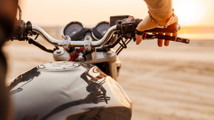 A confident rider prepares for a journey, embodying freedom and resilience against a serene sunset backdrop.