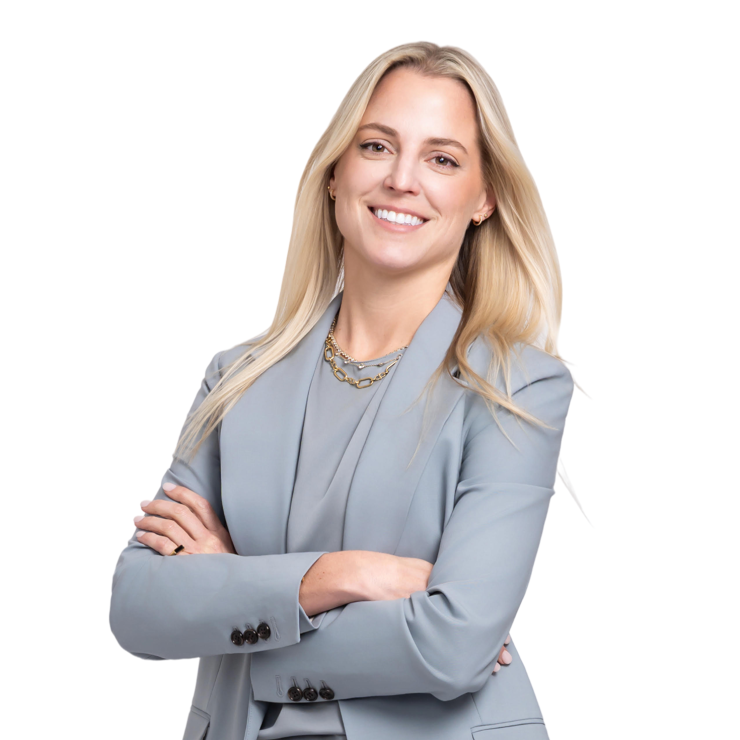 Confident professional woman in light gray suit, arms crossed, smiling with approachability and trust.