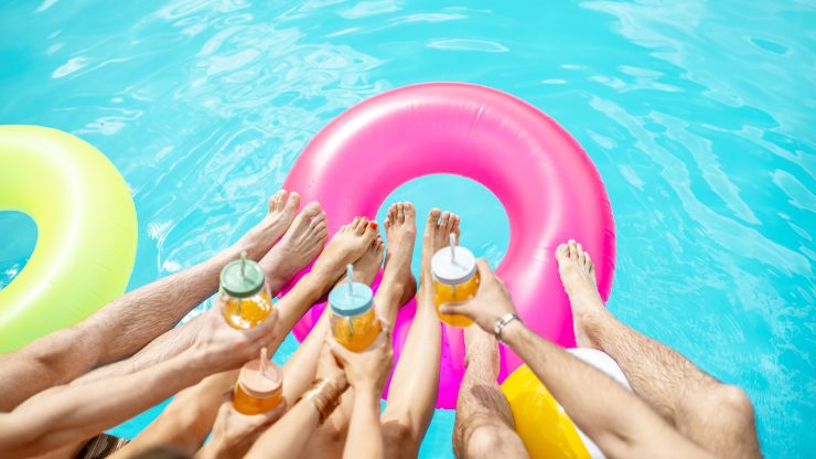Group relaxing by the pool, raising drinks in a moment of support and togetherness.