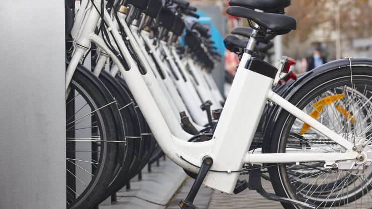 Urban electric bikes securely docked and charging, highlighting safe and reliable mobility options.
