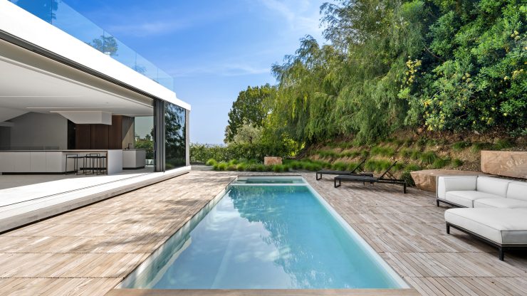 Modern outdoor pool area with clean lines, lush greenery, and a calm, secure atmosphere.