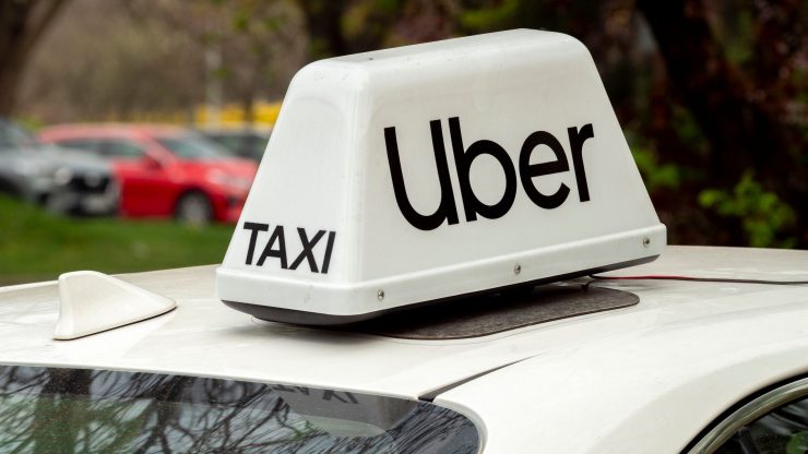 Close-up of a white Uber taxi sign on a car roof in Wrocław, Poland.