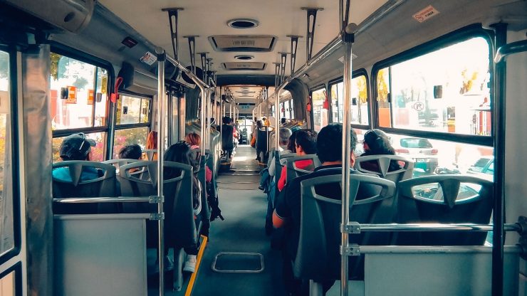 View inside an urban bus showing passengers seated during the day.